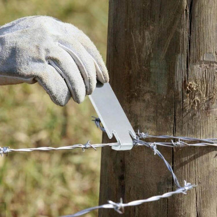 Wire Twister T-Post Clamp Fence Winder, 2 Pack For Easy Fencing being used to wind barbed wire around a wooden T-post with gloved hand