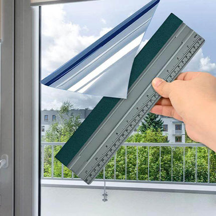 Auto Film and Wallpaper Scraper Tool with Graduated Scale held against window with breathable felt edge for film removal and precise inch/cm measurements