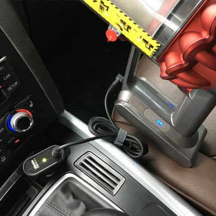Portable Car Charger for Dyson V10 and V11 Vacuum Cleaners plugged into car cigarette lighter charging a Dyson vacuum on a road trip