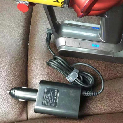 Portable Car Charger for Dyson V10 and V11 Vacuum Cleaners plugged into car cigarette lighter next to Dyson V10/V11 dock