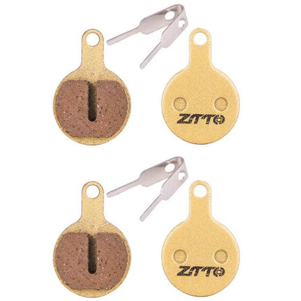 ZTTO Mountain Bike Brake Pads Full Metal Copper Base shown as four round copper-backed pads with two metal spring clips for MTB braking