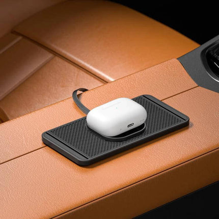 Car Magnetic Wireless Charging Anti Slip Pad For Phones on tan car armrest with wireless earbuds charging on black silicone anti-slip pad