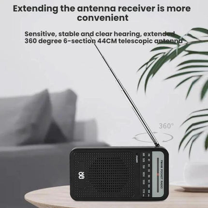 Portable AM/FM Radio with Analog Pointer Tuning for Daily Use showing extended telescopic antenna on tabletop