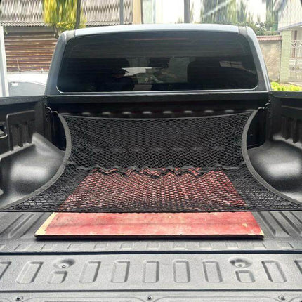 Single Layer Storage Netting For Pickup Truck Beds installed along bed wall holding tools and board in a pickup bed