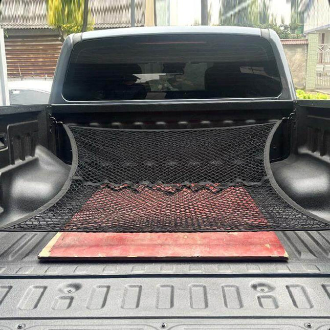 Single Layer Storage Netting For Pickup Truck Beds installed along bed wall holding tools and board in a pickup bed