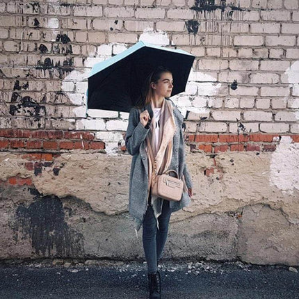 Compact Women's Folding Umbrella for Rain and Sun Protection - woman holding compact umbrella while commuting, lightweight portable design for travel and daily use