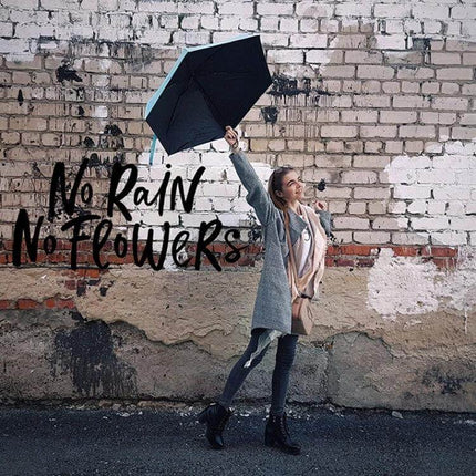 Compact Women's Folding Umbrella for Rain and Sun Protection held by smiling woman walking outdoors, compact portable design, rain and sun coverage