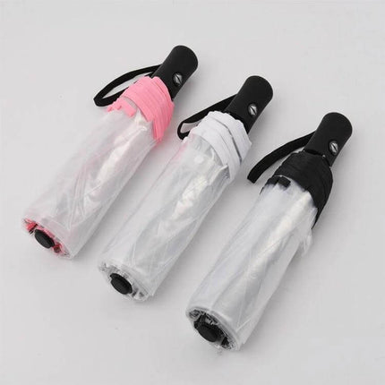 Compact Transparent Automatic Three-Folding Umbrella for Everyday Use shown folded in pink, white, and black handles for easy storage and visibility