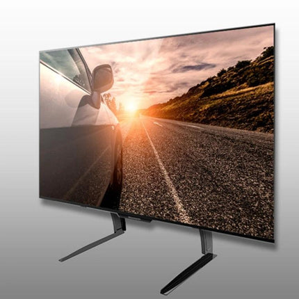 Adjustable Desktop TV Stand for 35-72 Inch Screens showing a black cold-rolled steel stand supporting a large flat-screen TV on a desk