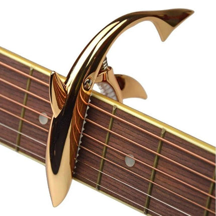 Shark-Shaped Capo for Everyday Guitar Music Sessions on acoustic guitar fretboard, gold shark design for quick key changes
