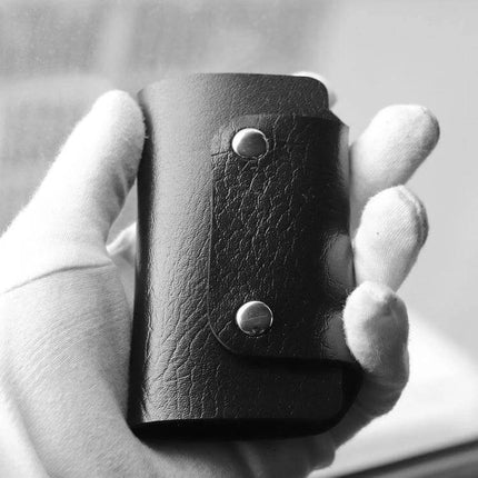PU Leather Car Key Cover 2 Pack For Everyday Key Storage - black PU leather key cover held in hand, protective snap closure
