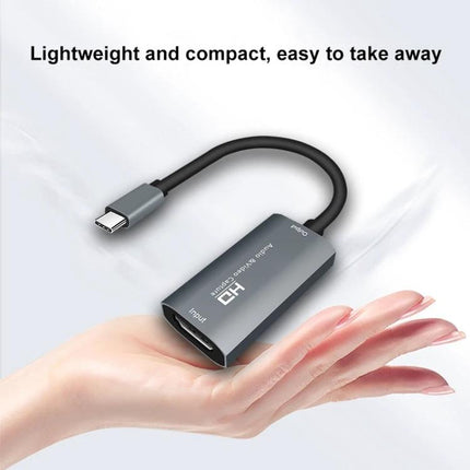 Portable HDMI to USB-C Video and Audio Capture Device for Recording compact HDMI-to-USB-C capture device shown in hand for gaming streaming and recording