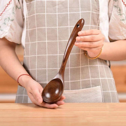 Teak Wood Kitchen Utensil Set Nonstick Pot Shovel And Spoons - polished teak ladle held by person in apron, gentle on nonstick cookware