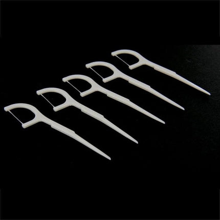 Tooth Pick With Thread, Wide ABS Dental Floss, 50 Pack - white ABS floss picks lined up on black background for interdental cleaning