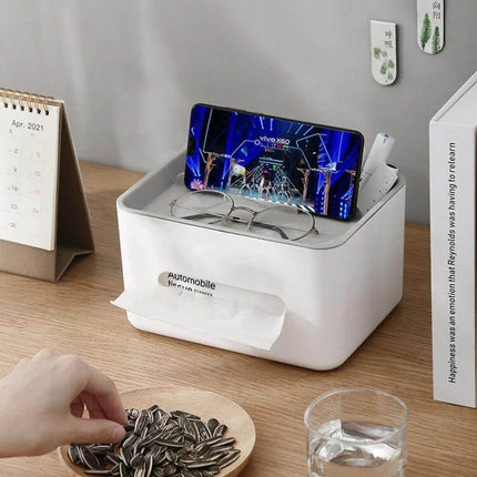 Two-Compartment Tissue Box And Remote Organizer For Desk on wooden desk holding phone, glasses, remotes and tissues