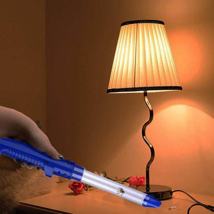 USB Charging Insect Catcher With LED Light For Home Use Blue shown catching small flying insects on a bedside table under a lamp