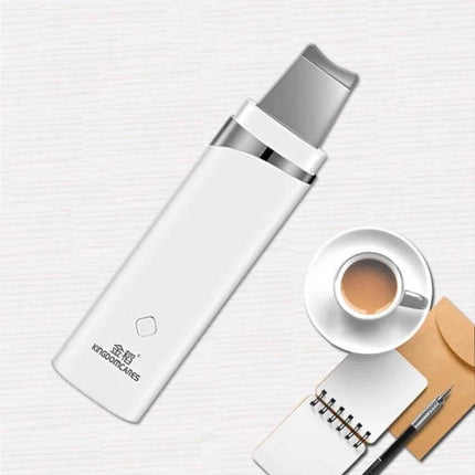 Ultrasonic Blackhead Remover Pore Cleaner For Facial Care - white handheld ultrasonic pore cleaner on desk with coffee and notebook