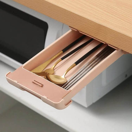 Under Desk Drawer Storage Box With Pull Out Pen Storage in pink under-desk tray holding pens, cutlery and small items to reduce desktop clutter