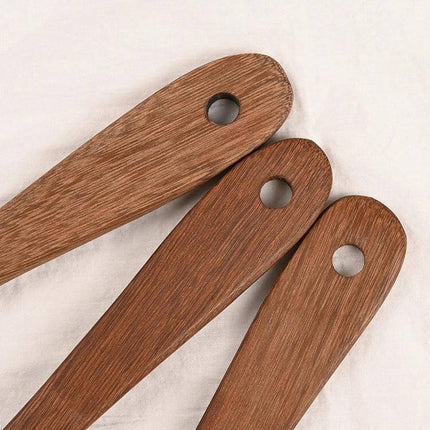 Unpainted Wooden Spatula Set, Long-Handle Utensils showing three natural wood perforated handles with hanging holes and visible wood grain