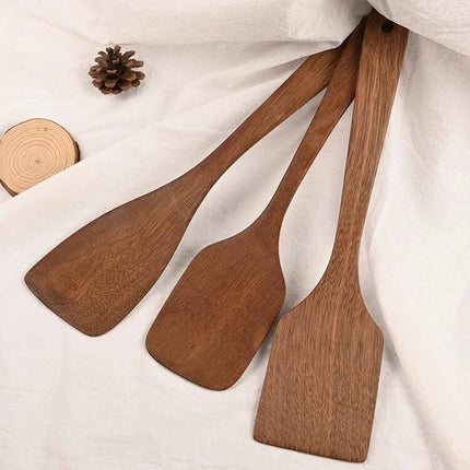 Unpainted Wooden Spatula Set, Long-Handle Utensils arranged on cloth showing natural wood grain and perforated practical kitchen tools