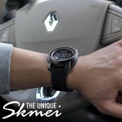 SKMEI Men's Outdoor Waterproof Digital Sports Watch on wrist in car interior, digital display showing time and date, rugged black band