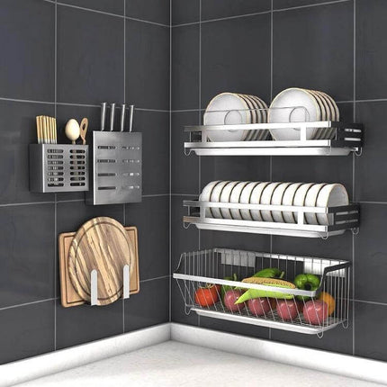 Wall-Mounted Knife Holder for Kitchen Organization mounted on dark tile wall with stainless steel racks holding knives, plates, cutting boards and fruit