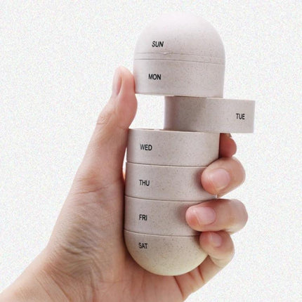 Wheat Straw Pill Storage Box 7 Day Sealed Organizer in hand, compact grain-fiber weekly pill case with labeled compartments SUN-MON-TUE-WED-THU-FRI-SAT