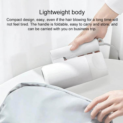 Xiaomi Mijia Negative Ion Portable Hair Dryer With Foldable Handle compact white model being placed into a travel bag, lightweight foldable design
