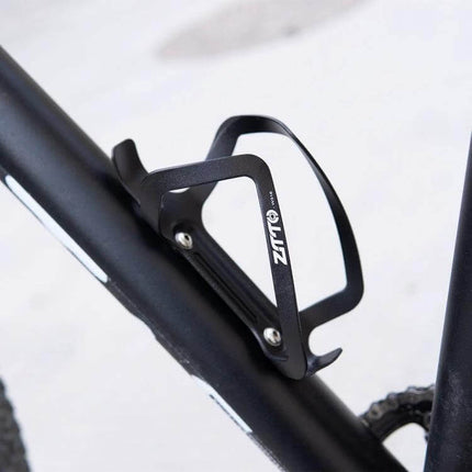 ZTTO Aluminum Bicycle Water Bottle Cage Ultralight Holder mounted on black mountain bike frame, lightweight corrosion-resistant aluminum bottle cage
