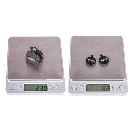 ZTTO Bicycle Disc Braking Pads For Mountain Bike Everyday Use on scales showing weight comparison, copper fiber pads with steel backing plate