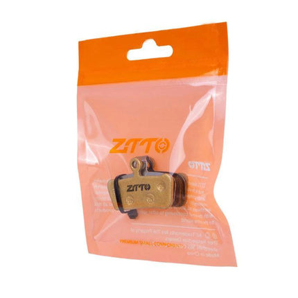 ZTTO Mountain Bike Brake Pads Full Metal Copper Base packaged replacement pads in orange retail bag, close-up of copper-backed pads