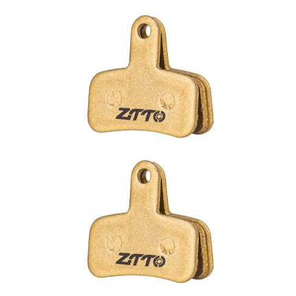 ZTTO Mountain Bike Brake Pads Full Metal Copper Base shown as two gold-colored pads with ZTTO logo, durable low-noise braking for trail and urban riding