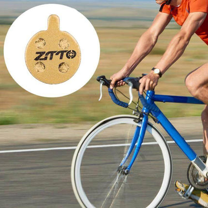 ZTTO Mountain Bike Brake Pads Full Metal Copper Base shown on road bike with rider, durable low-noise braking for wet dusty trail and urban use