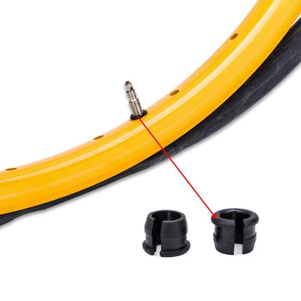 ZTTO Schrader To Presta Rim Adapter For Mountain Road Bikes 10 Pack - close-up of black plastic adapter next to yellow rim and Presta valve