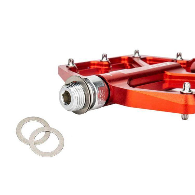 ZTTO Stainless Steel Pedal Washers for Mountain Bike Cranks shown next to red flat pedal protecting crank and pedal threads