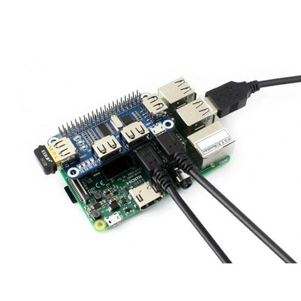Waveshare 4-Port USB Hub HAT for Raspberry Pi Devices mounted on Raspberry Pi with multiple USB cables connected