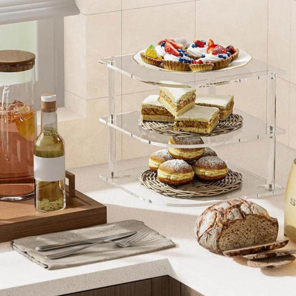 Acrylic 3 Tier Corner Plates and Bowls Organizer Shelf holding cakes, sandwiches and doughnuts on a kitchen countertop