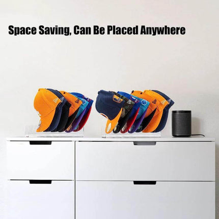 Acrylic Baseball Cap Holder Stores 7 Caps For Easy Countertop Organization showing two transparent acrylic racks holding colorful baseball caps on a white dresser, space-saving display