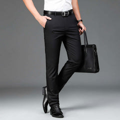 Man wearing Bamboo Fiber Lightweight Casual Business Trousers in black color, holding a black leather bag, styled for modern fashion and comfort.