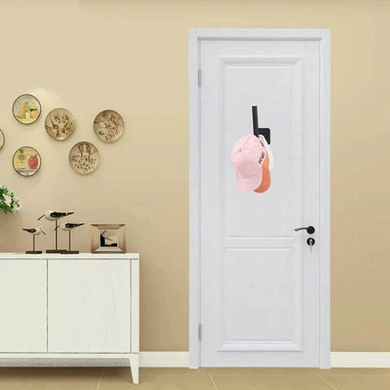 Baseball Hat Wall Hook Self-Adhesive 2-Pack Black/White shown mounted on a white door holding two caps, durable self-adhesive black and white hooks