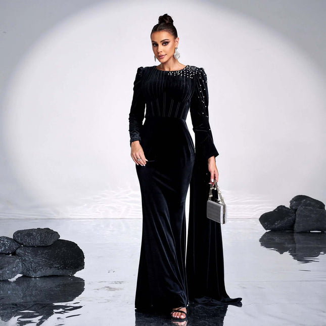 Black Velvet Round Neck Long Sleeve Rhinestone Evening Dress modeled with subtle rhinestone shoulder detail, long sleeves, and small evening clutch