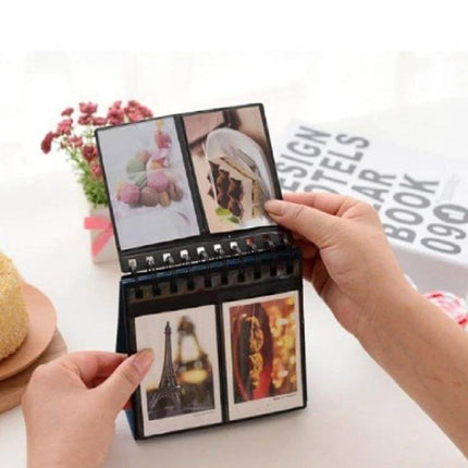 Calendar Style Desktop Standing Folder Album 68 Photos - compact vertical desktop photo album shown open with hand flipping pages