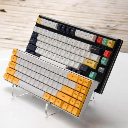 Detachable Keyboard Stand for Everyday Desk Setup at Home showing clear acrylic stand holding two compact keyboards on a tidy home desk