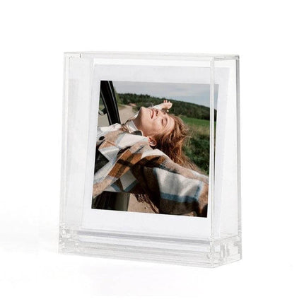 Photo Frame Stand for Polaroids - Double-Sided for Easy Display showing a clear polycarbonate stand holding a square photo in natural light