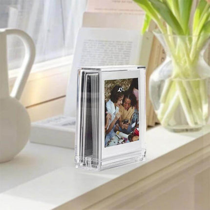 Photo Frame Stand for Polaroids - Double-Sided for Easy Display on a desk showing clear polycarbonate double-sided Polaroid holder with stacked prints