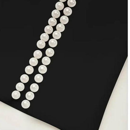 Elegant Pearl Accent Dress With Slit Sleeves For Everyday Wear - close-up of black polyester dress with vertical pearl accents