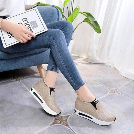 Flat PU Leather Womens Sneakers For Everyday Casual Wear - gold slip-on low-profile flat sneaker with cushioning sole shown on model sitting