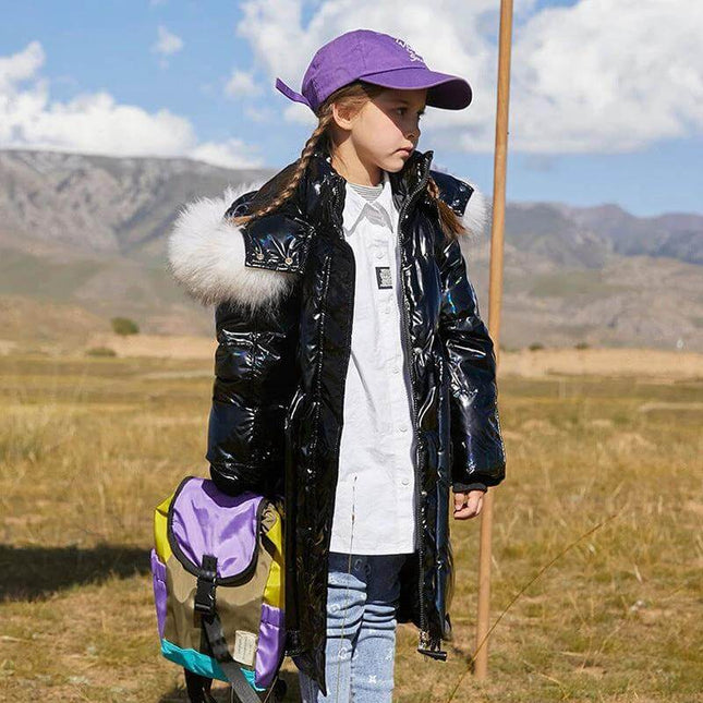 Girls' Fashion Simple Mid-Length Thick Coat Pink For Everyday Wear - girl wearing long black puffer coat with fur hood, purple cap and backpack in field
