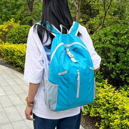 HAWEEL Hiking Backpack Large Capacity For Outdoor Use - foldable tear- and water-resistant daypack in blue carried on a woman outdoors