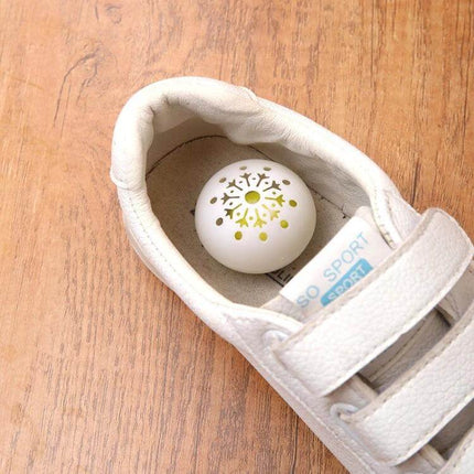 Hollow Ball Shoe Cabinet Deodorant Freshener For Shoes And Home - white hollow ball deodorizer placed inside white sneaker to freshen shoes and closets